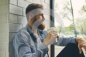 Bearded man drinking takeaway coffee