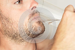 Bearded man drinks water from a glass