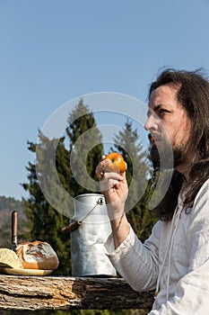 Bearded man eating an apple in the nature