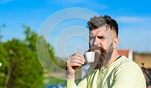 Bearded man with espresso mug, drinks coffee. Coffee break concept. Man with long beard looks strict and serious. Man