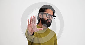 Bearded man with eyeglasses showing stop gesture