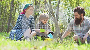 Bearded man farmer and pin-up retro Mather teaching son in the farm working. Dad mom and son. Family farmer concept