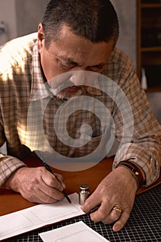 bearded man focus on working with stitching awl at workplace