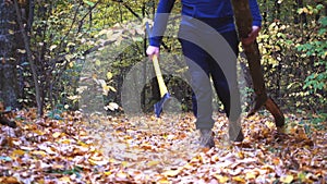 Bearded man in the forest with an ax slowing down.