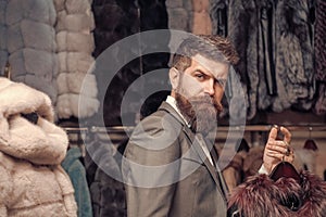 Bearded man among fur, luxury, moneybags, business