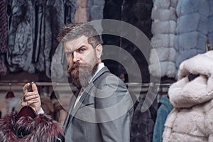 Bearded man among fur, luxury, moneybags, business