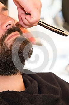 Bearded Man Getting Beard Haircut By Barber in barbershop