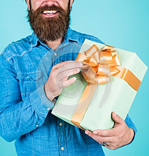 Bearded man gift holiday decoration. businessman holding big gift box. gift to colleague at work. surprised man