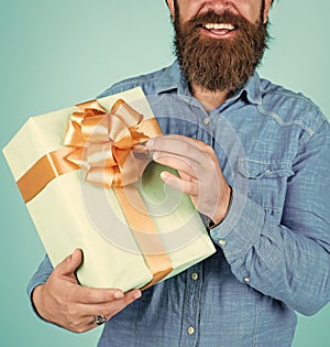 Bearded man gift holiday decoration. businessman holding big gift box. gift to colleague at work. surprised man