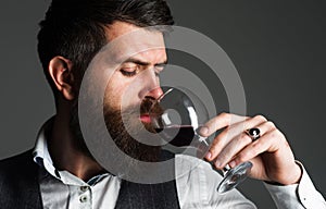 Bearded man with glass of red wine. Tasting alcohol. Sommelier, degustator. Winery, male winemaker.