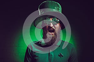 bearded man in green irish hat and funny eyeglasses screaming photo