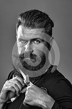 Bearded man with hairdresser scissors