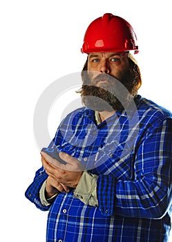 Bearded man in a hard hat with a smart phone