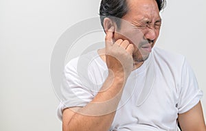 Bearded man has an itchy ear or a pain in his ear isolated on white background. Health care