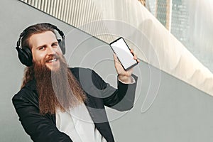 Bearded man in headphones and with phone