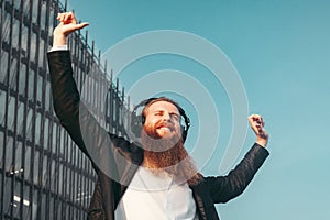 Bearded man in headphones rejoices