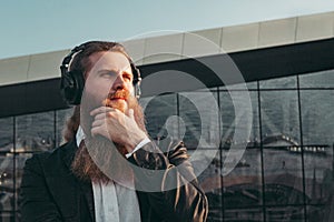 Bearded man in headphones thinking