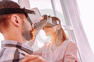 Bearded man helping his woman adjusting VR glasses