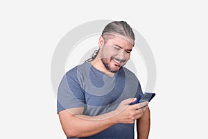 A bearded man in his 30s browsing on his cellphone. A male of mixed ancestry. Isolated on white background