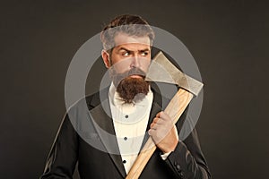 Bearded man hold axe at unshaven face. Axe shaving. Barbering. Barbershop