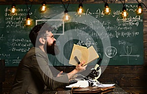 Bearded man hold books in university. Scientist research with microscope. Man with beard and mustache on chalkboard