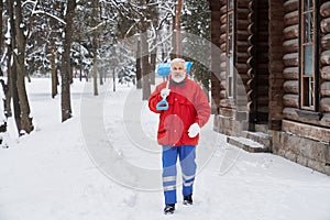 Bearded man holding shovel and going forward in park