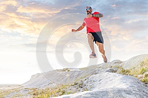 Bearded man jump from hill on trail running cross
