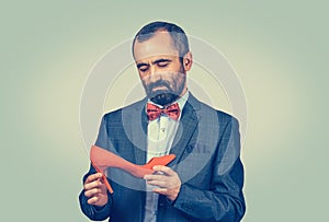 Bearded man keeping and looking to red high-heeled shoe
