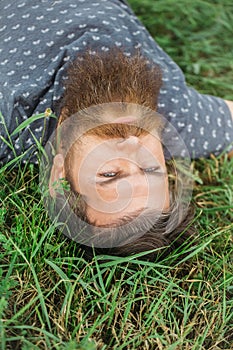 Bearded man laying on green grass