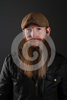 Bearded man with leather jacket and cap.