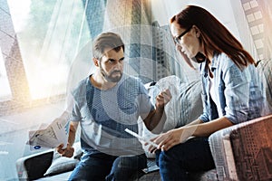 Bearded man looking angry and scrunching paper in his hands