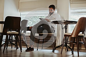 Bearded man looking at the tablet screen in a cafe