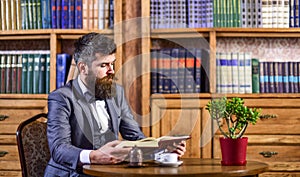 Bearded man in luxury suit in old library.