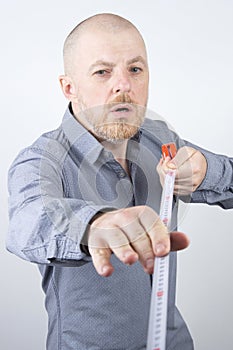 Bearded man makes a measuring tape measure centimeter