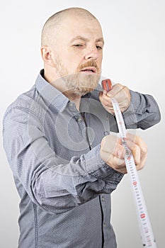 Bearded man makes a measuring tape measure centimeter