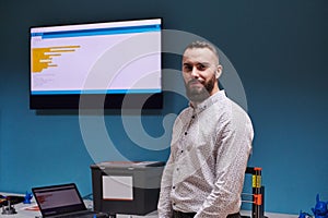 A bearded man in a modern robotics laboratory, immersed in research and surrounded by advanced technology and equipment