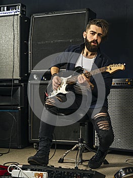 Bearded man playing guitar in a music studio