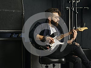 Bearded man playing guitar in a music studio