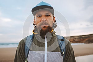 Bearded man portrait outdoor brutal guy wearing cap walking with backpack travel lifestyle