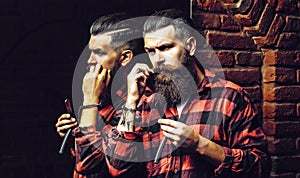 Bearded man with razor near mirror. Man with long beard. Handsome man hipster or guy with beard and moustache on serious