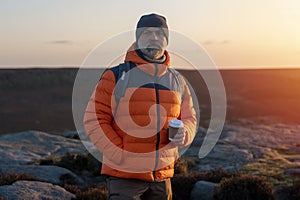 Bearded Man reaching the destination and on the top of mountain at sunrise or sunset on cold day Travel Lifestyle concept The