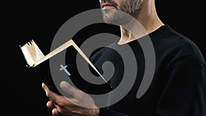 Bearded man reading holy bible, praying God against dark background, psalm