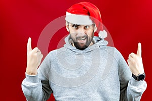 A bearded man in a red Santa Claus hat grins and makes various poses with his hands