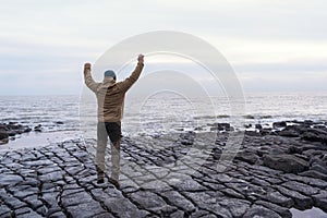 Bearded Man relaxing alone on seaside on cold winter day. Travel  Lifestyle concept