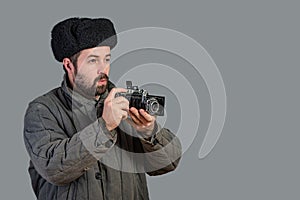 Bearded man with retro camera, studio shott. Old-fashioned clothing style. Concept - retro photography