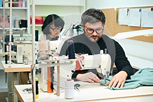 Bearded man is scribbling on a sewing machine photo