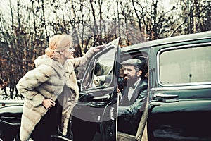 Bearded man and sexy woman in fur coat. Couple in love on romantic date. Travel and business trip or hitch hiking. Retro