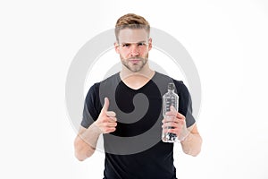 Bearded man show thumbs up with bottle of water. Thirsty man with beard in tshirt hold plastic bottle. Thirst and