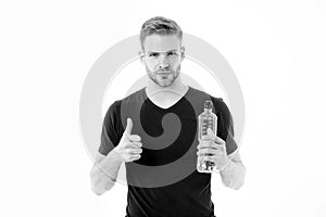 Bearded man show thumbs up with bottle of water. Thirsty man with beard in tshirt hold plastic bottle. Thirst and