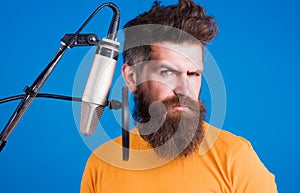Bearded man sing in condenser microphone. Male Professional vocalist. Singing in studio. Karaoke.